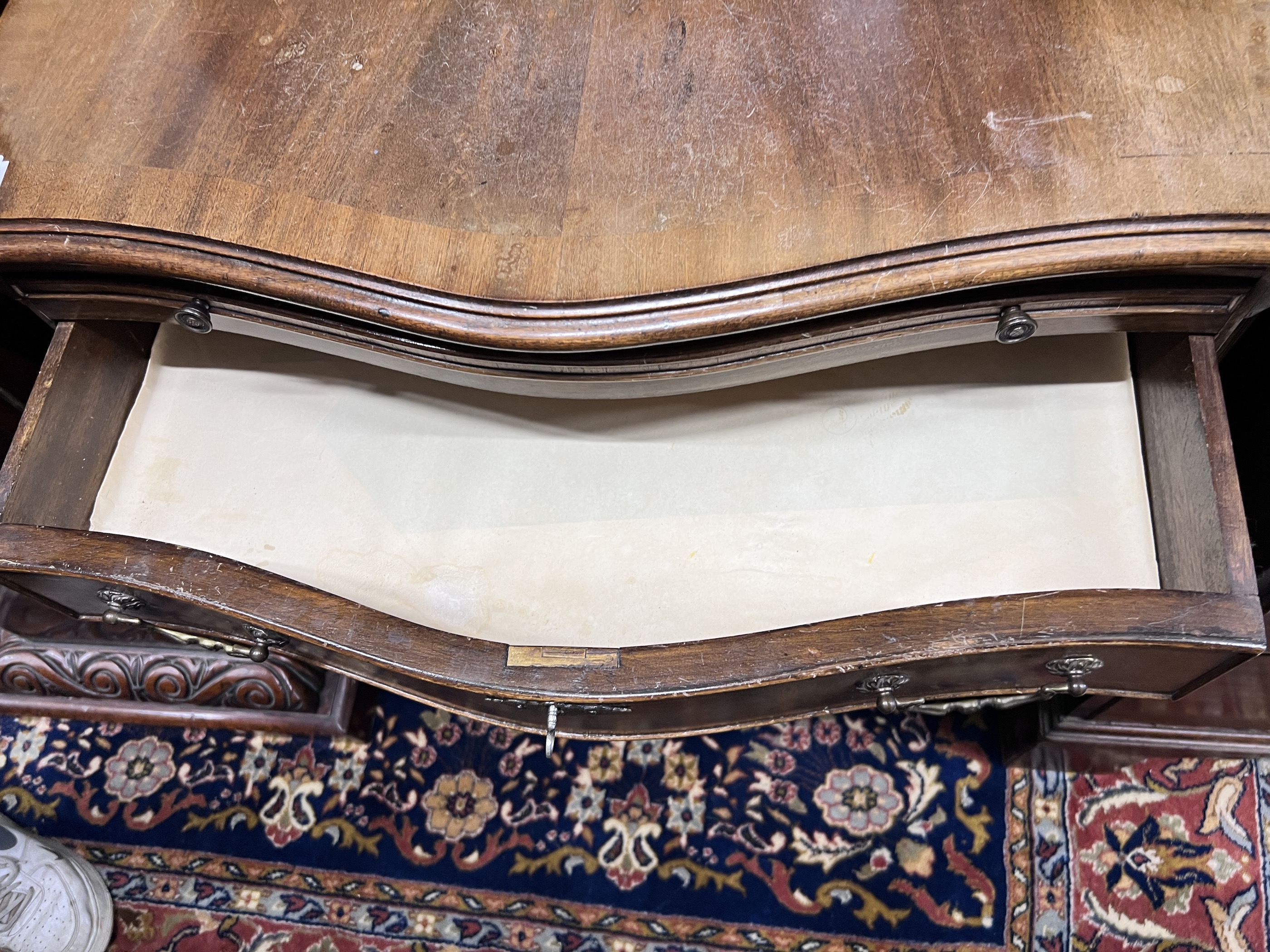 A small reproduction serpentine mahogany chest of four graduating long drawers with brushing slide, width 71cm